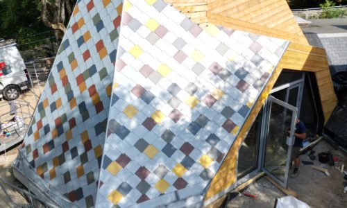 Façade de la halte-garderie Carrefour 18 à Rennes en cours de pose de bardage métallique en écailles